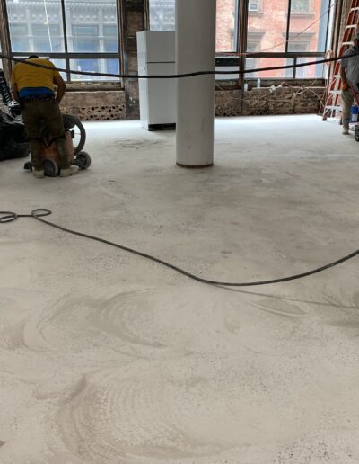 image shows a large room with a concrete floor being polished