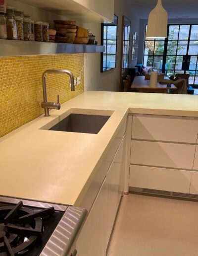 image shows a kitchen counter with a stainless steel sink and a stainless steel faucet