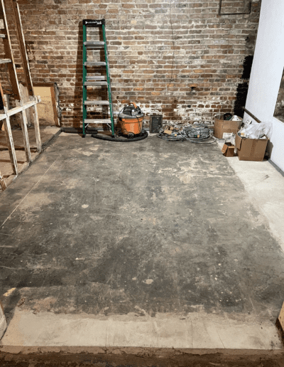 image shows a concrete floor with what looks like remnants of carpet padding stuck to it