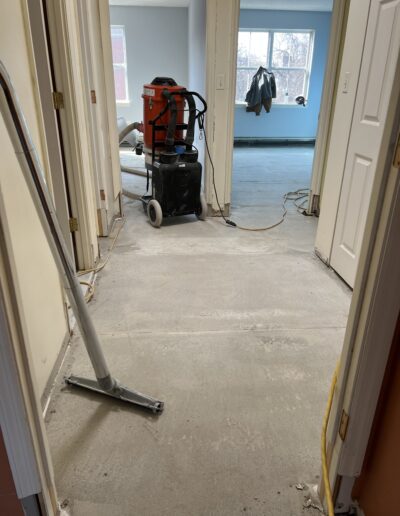 image shows a concrete floor that appears to be undergoing some sort of renovation or preparation work