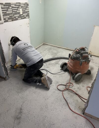 Clean floor with walls painted in sky blue, as a man is actively cleaning the floor