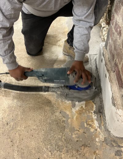 A man using a machine to fix a floor leakage, focusing on the area of the floor being repaired