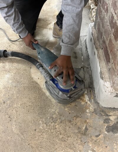 A man using a machine to fix a floor leakage, focusing on the repair process