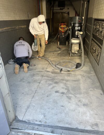 Two men are working on a garage floor