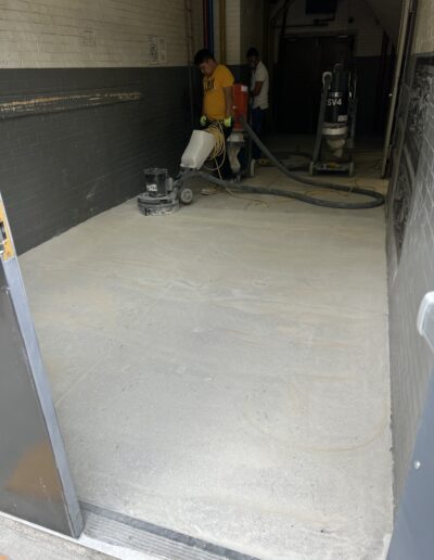 A couple of men working on a floor in a building